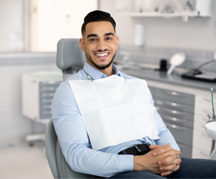 Male dental patient waiting in chair with hands folded