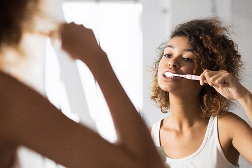 Arlington patient brushing teeth with aligners removed