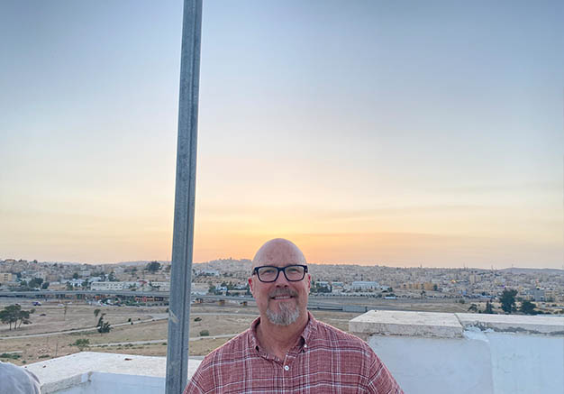 Man smiling in front of view of town