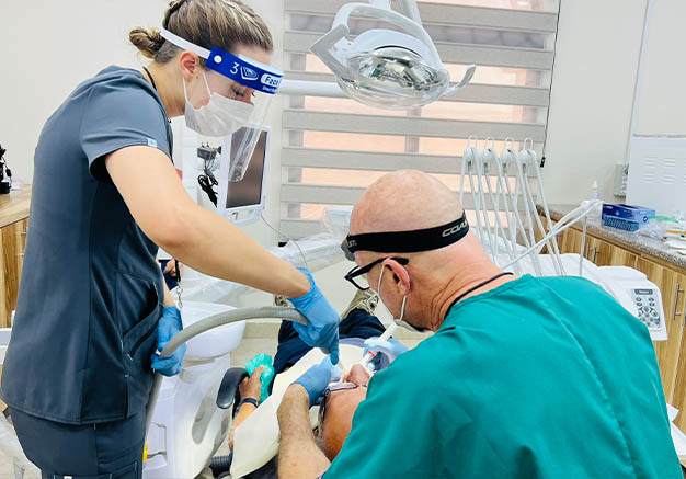 Two dental professionals treating a patient