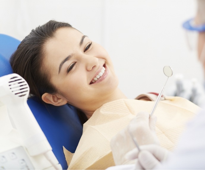 Woman smiling during dental checkup and cleaning in Arlington