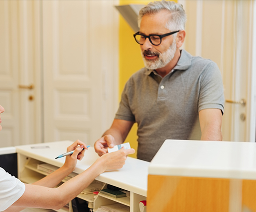 Man at front desk of dental office