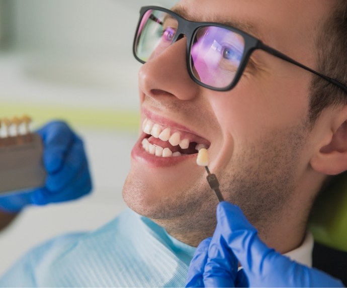 Man with glasses having teeth color matched