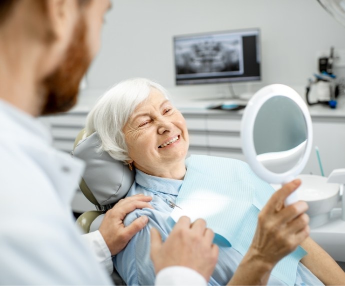 Senior woman sitting in dental chair and smiling