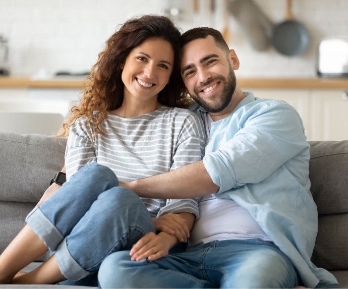 Man and woman sitting on couch and smiling