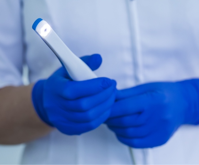 Gloved hands holding an intraoral camera