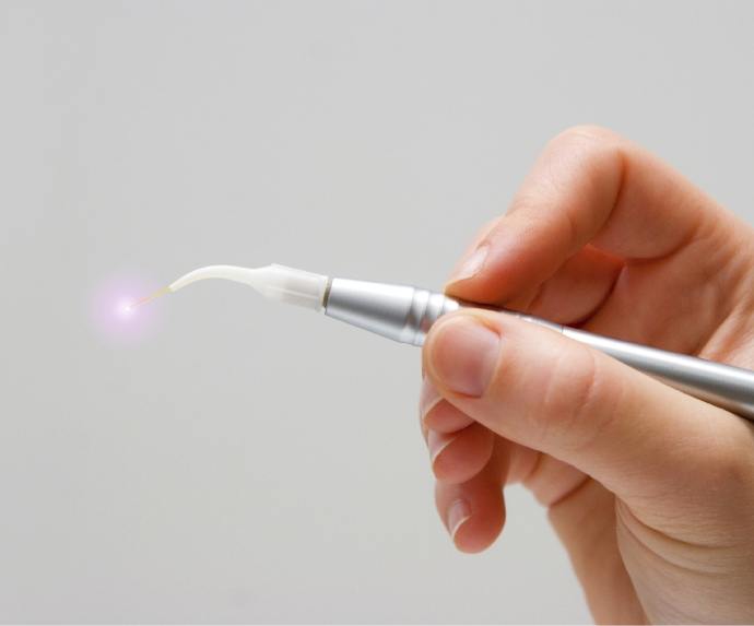 Hand holding a dental soft tissue laser