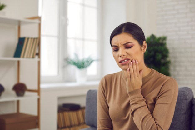 Woman sitting on chair with tooth pain