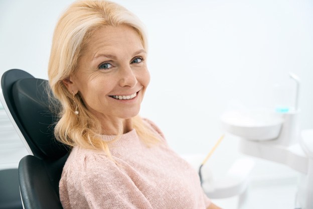 Senior woman sitting in dental chair and smiling