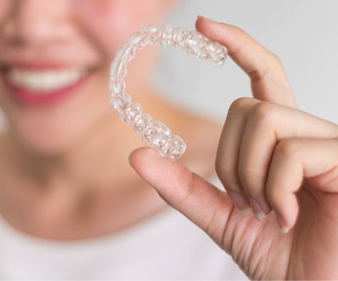 Woman holding an aligner for ClearCorrect