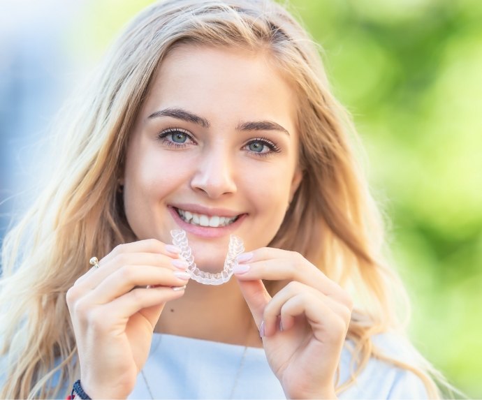 Blonde woman putting in a ClearCorrect aligner