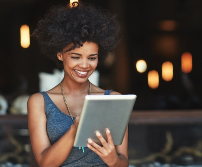 Woman looking at a tablet and smiling